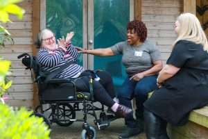 Person in a wheelchair having a laugh with carers