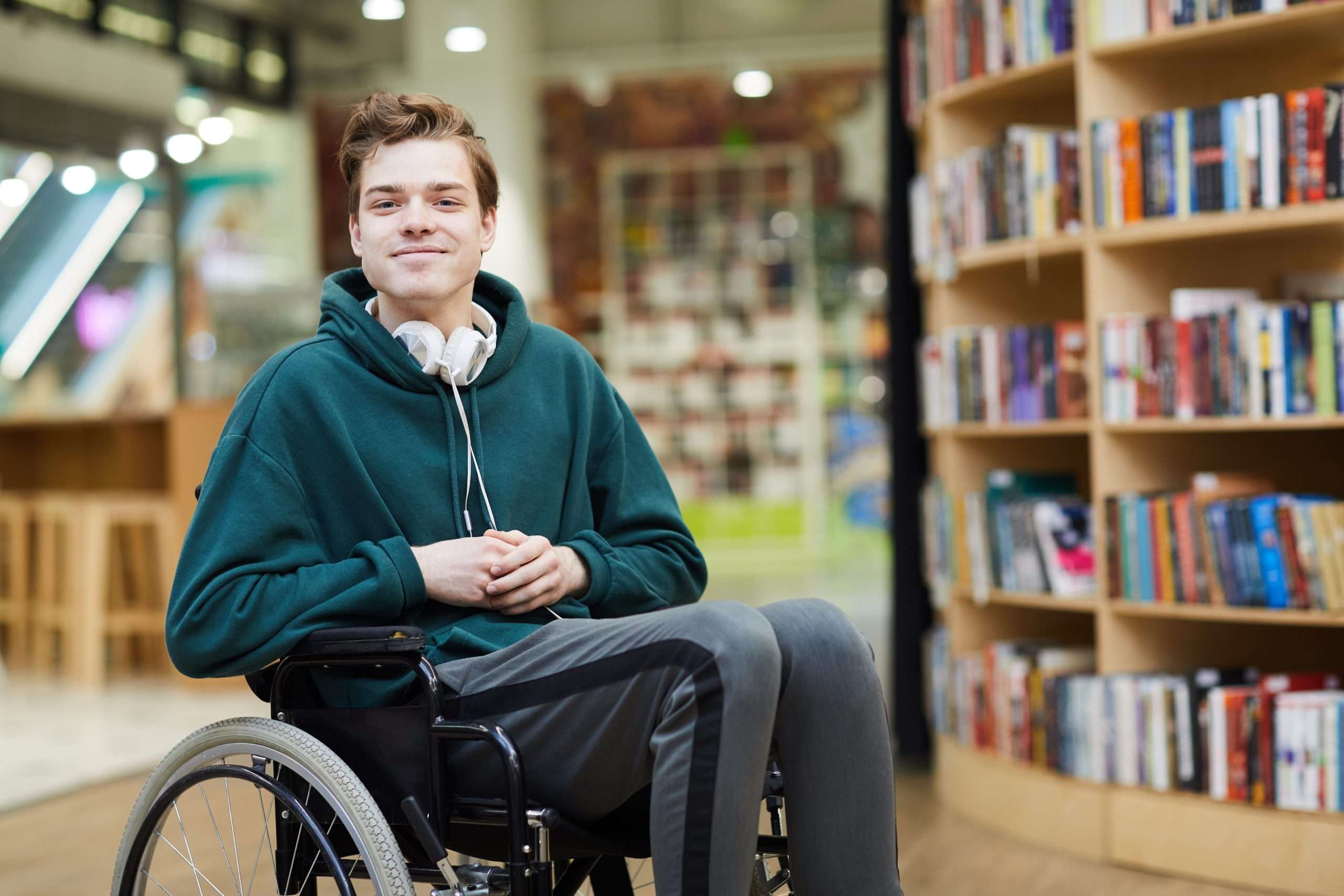 child to adult care - a young adult in a wheelchair smiling at the camera