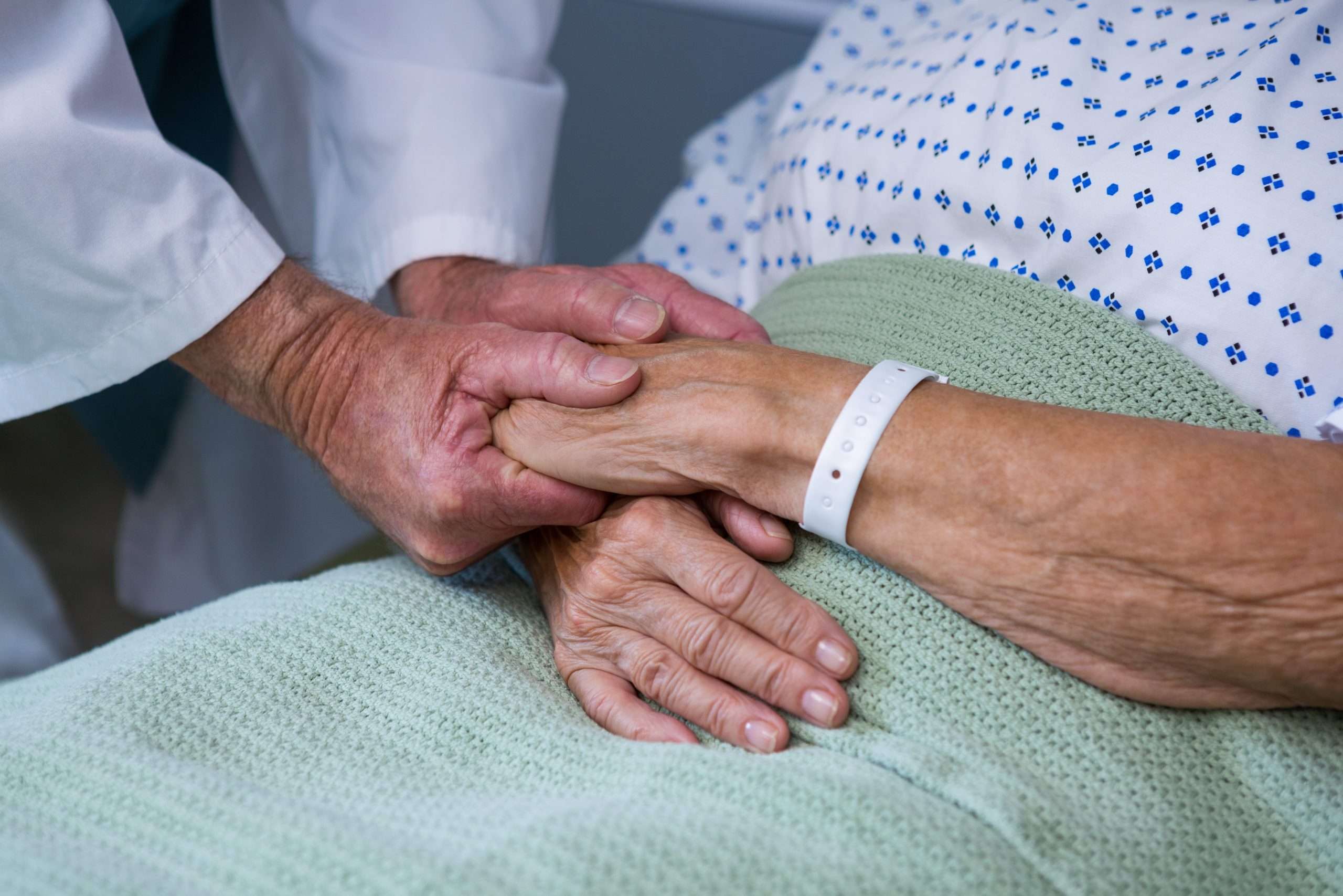 how-soon-can-live-in-care-start-2 How soon can live in care start? A person in hospital with hands being held.